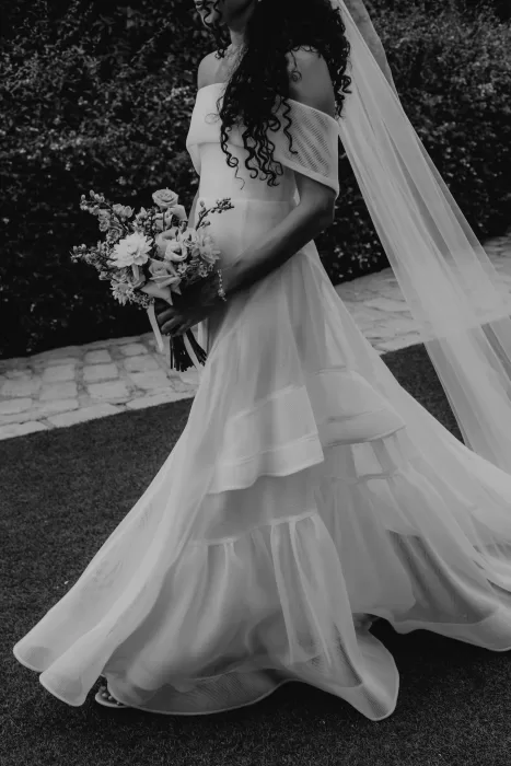 Bride in off-shoulder gown holding pastel bouquet at Cigarral de las Mercedes.