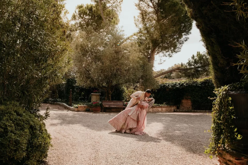 Groom dips the bride in a romantic moment in the sun-dappled courtyard of Cigarral de las Mercedes.