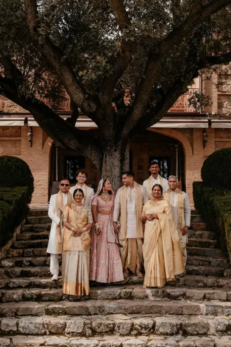Wedding family portrait on the stone steps beneath an old tree at Cigarral de las Mercedes.