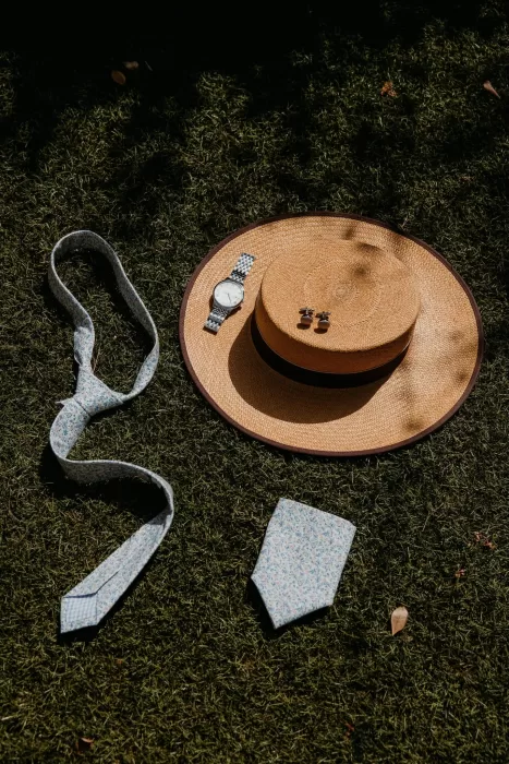 Groom’s wedding accessories laid out with hat, tie, and cufflinks at Cigarral de las Mercedes.