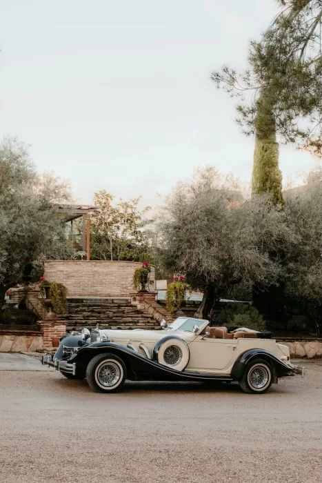 Classic vintage car parked outside the rustic stone entrance of Cigarral de las Mercedes.