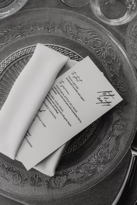 Elegant wedding dinner menu placed on a glass charger plate at Cigarral de las Mercedes.
