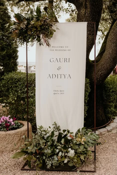 Elegant wedding welcome sign with greenery announcing Gauri and Aditya's celebration at Cigarral de las Mercedes.