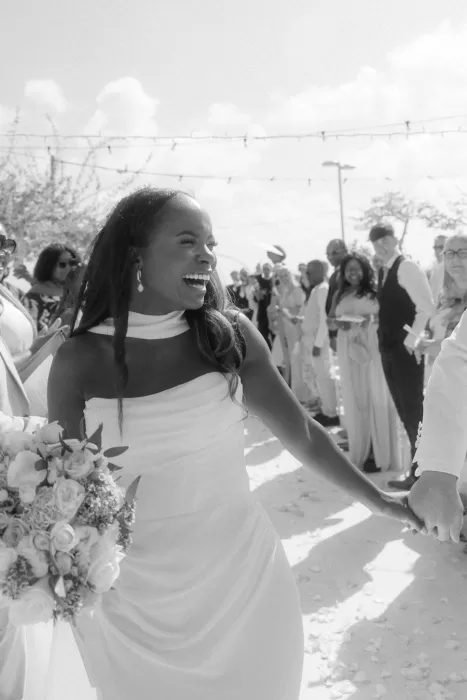 Bride laughing joyfully while holding bouquet during wedding celebrations at Coral Residences.