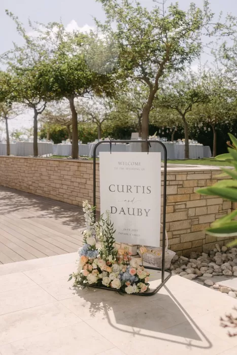 Elegant wedding welcome sign with floral arrangement at Coral Residences.