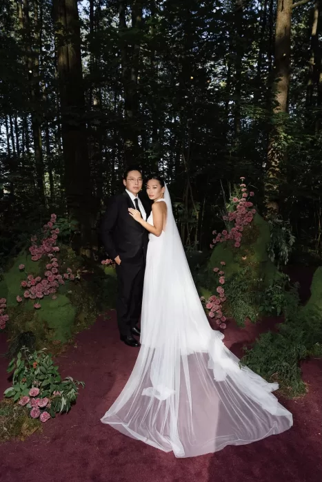 Bride and groom standing together on moss-lined aisle in forest wedding setting, photographed by Sergey Skripnik.