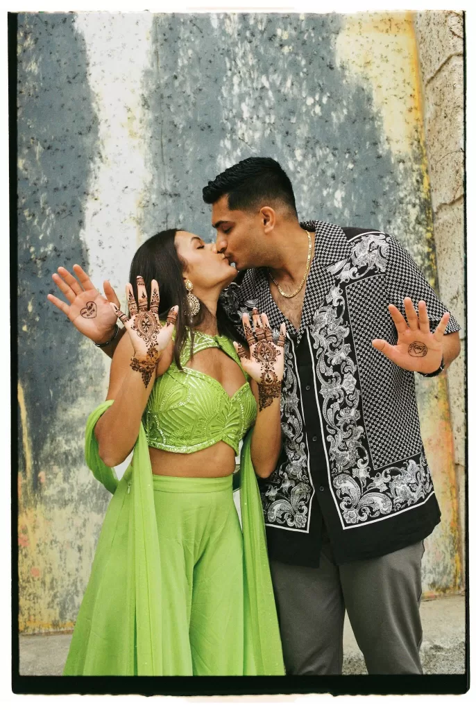 Couple sharing a kiss while showing off their matching henna designs at Cigarral de las Mercedes.