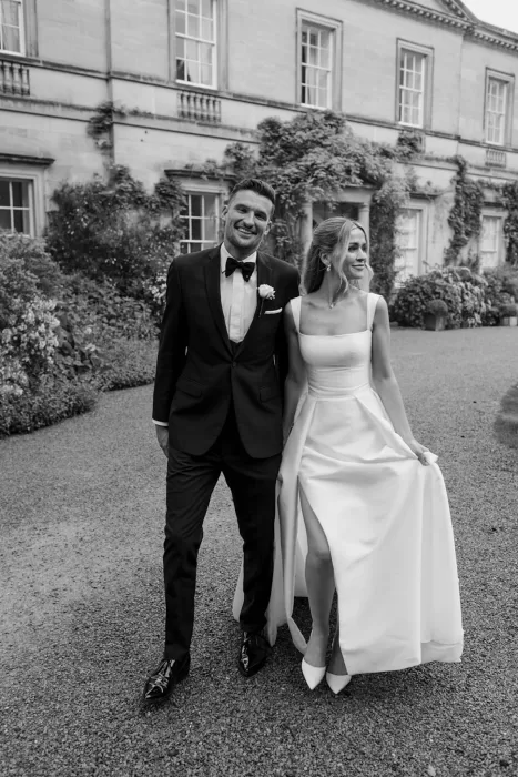 Bride and groom smiling together while walking outside Middleton Lodge.