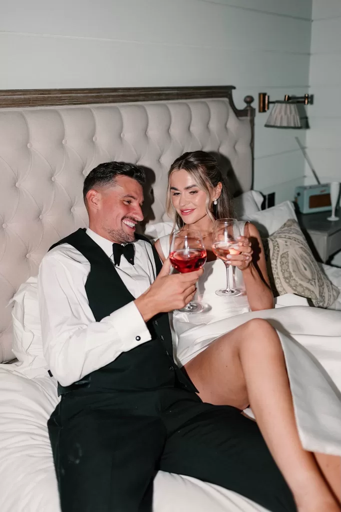 Newlyweds toasting with glasses of rosé in their Middleton Lodge suite.