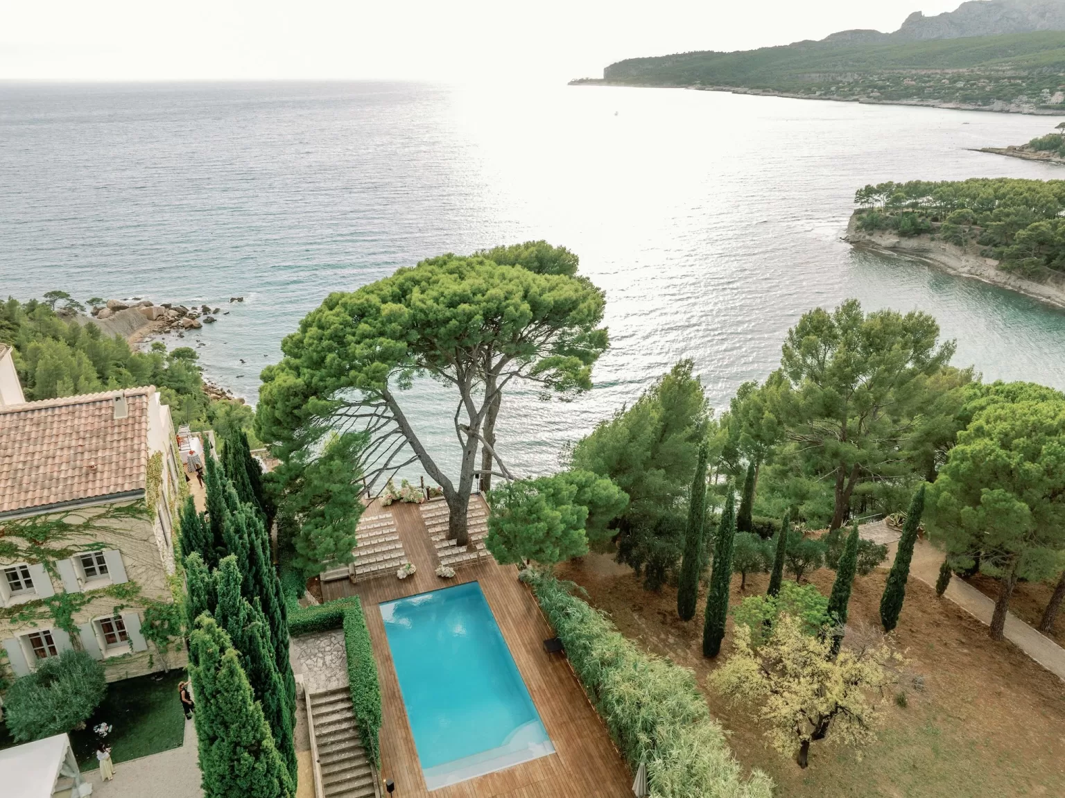Pool terrace framed by pine trees with panoramic sea views at Domaine de Canaille