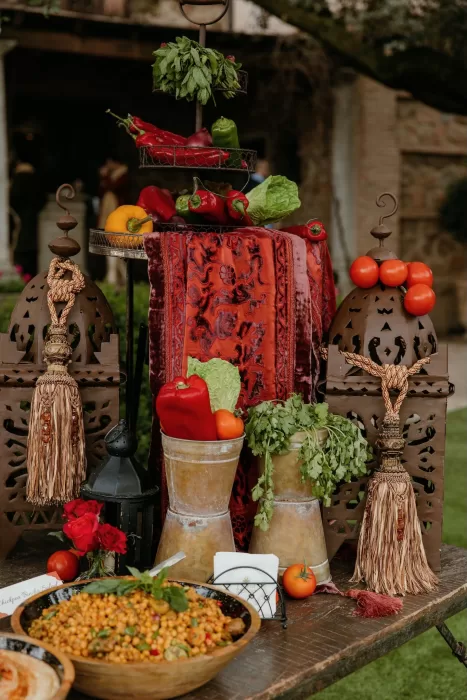 Colourful wedding food display with fresh herbs, vegetables, and Moroccan lanterns.