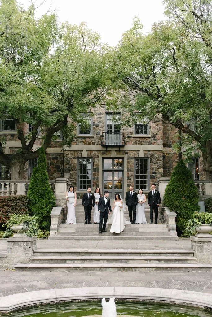 Bride and groom with their wedding party standing on the stone steps of Graydon Hall.