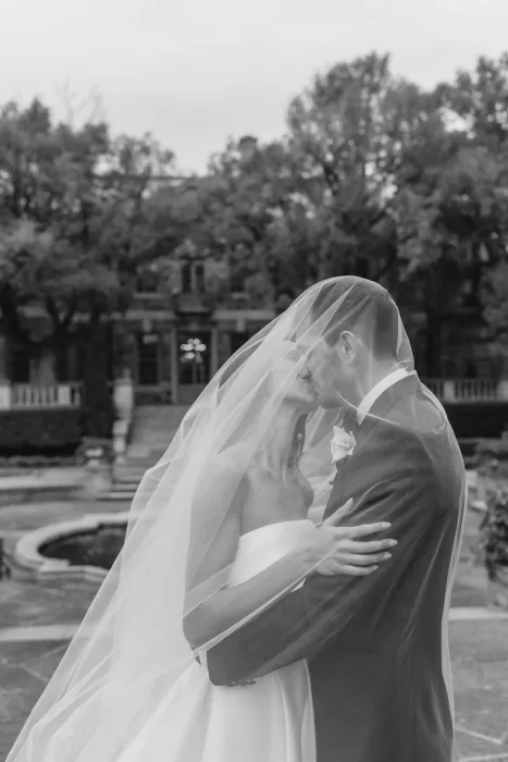 Romantic black and white photo of the bride and groom sharing a kiss beneath the veil at Graydon Hall.