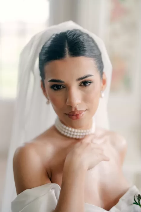 Close-up bridal portrait with pearl choker and veil, looking serene at Hedsor House.