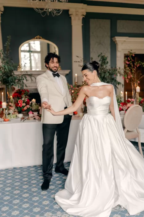 Bride and groom sharing a joyful dance in the elegant ballroom at Hedsor House.