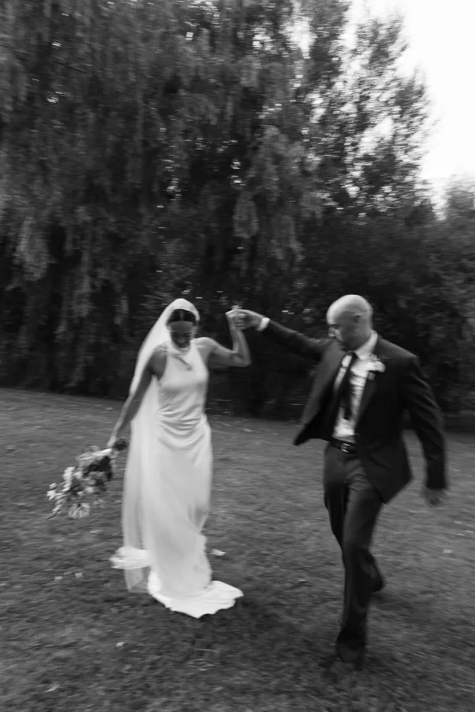Bride and groom dancing joyfully in a blurred candid shot at La Farinera de Sant Lluis.