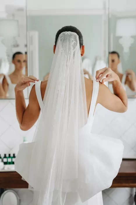 Back view of bride adjusting her straps, showcasing her veil and structured bow at Le Mas Barossa.