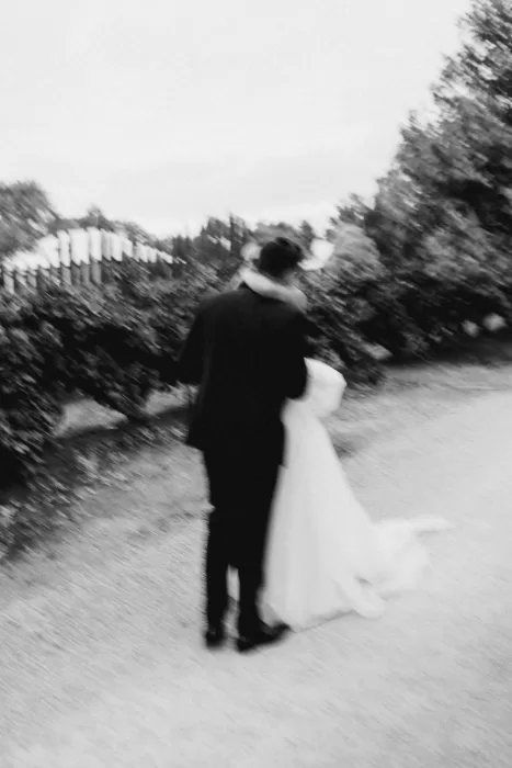 Artistic blurred image of a couple embracing as they walk through the vineyard path at Le Mas Barossa.