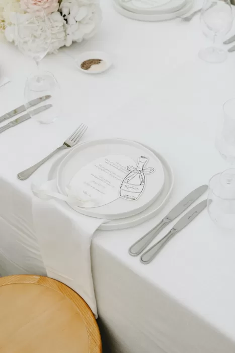 Minimalist wedding place setting at Le Mas Barossa with a custom illustrated menu and white linen napkin.