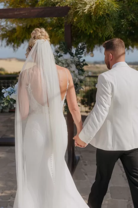 Bride and groom walking hand in hand down the wedding aisle at Liopetro.