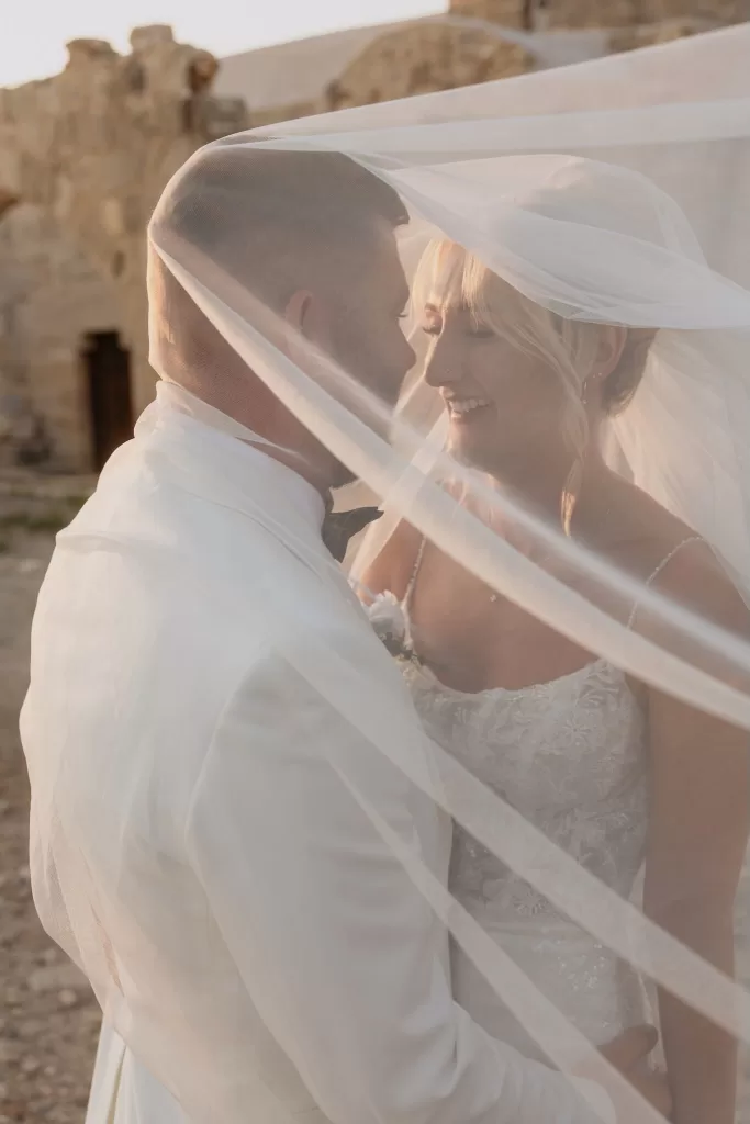 Intimate portrait of bride and groom under the veil at Liopetro with soft sunset light.