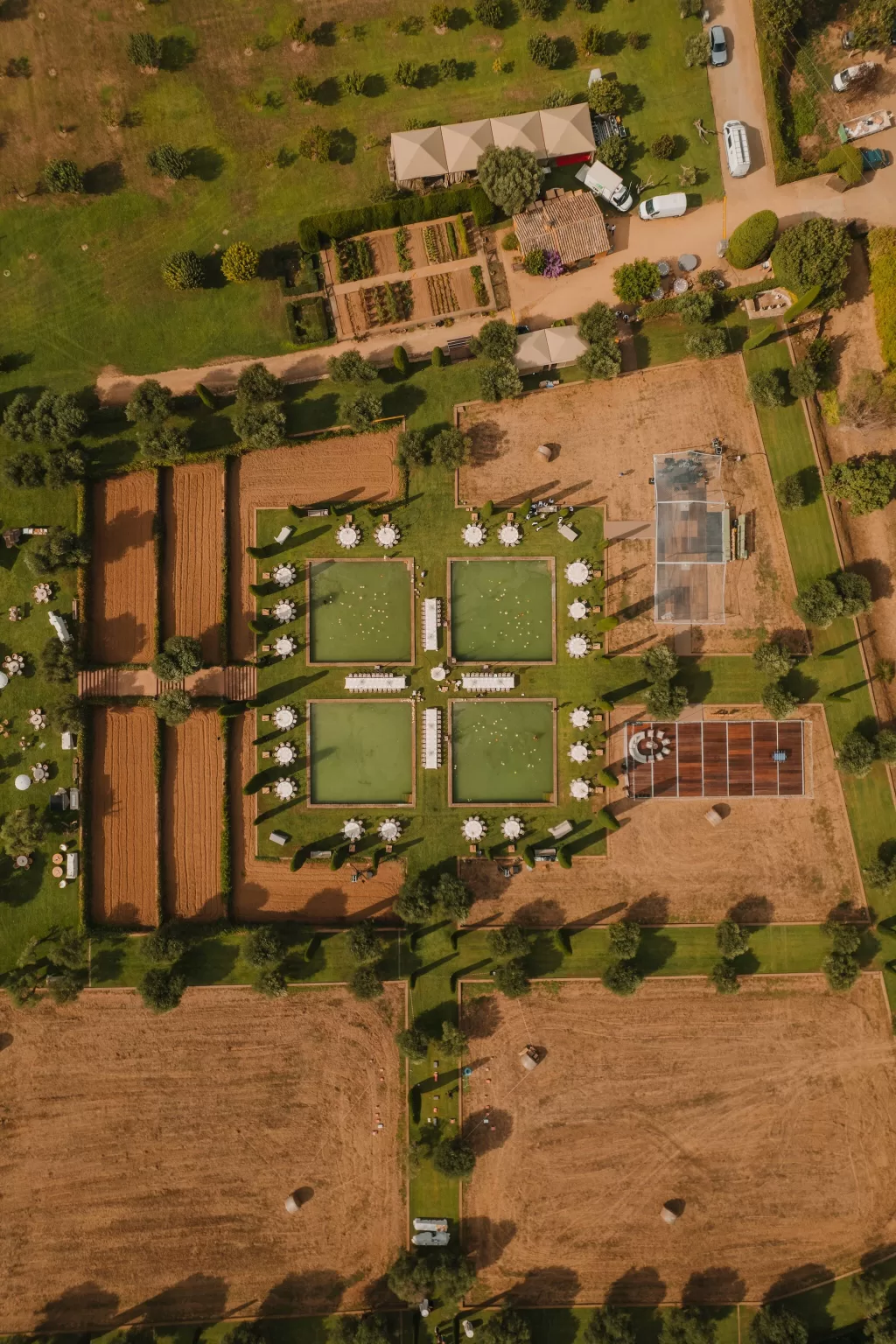 Daytime aerial view of Mas de Les Voltes gardens and poolside wedding setup.