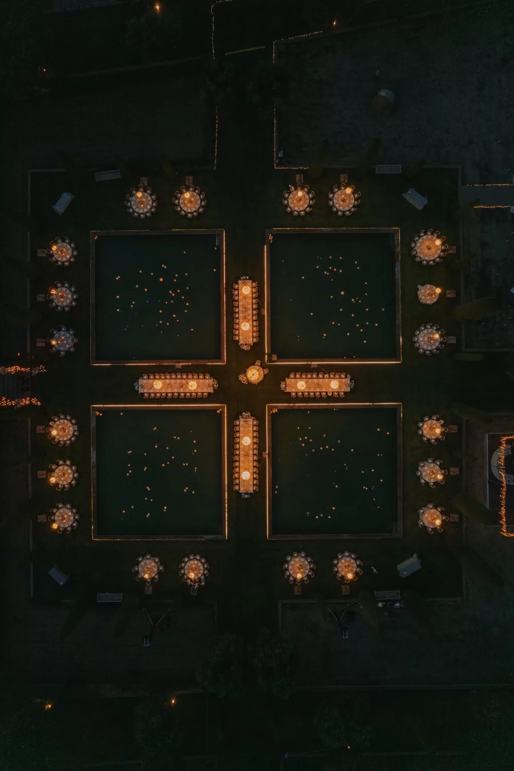 Night aerial view of Mas de Les Voltes wedding dinner with glowing poolside tables.