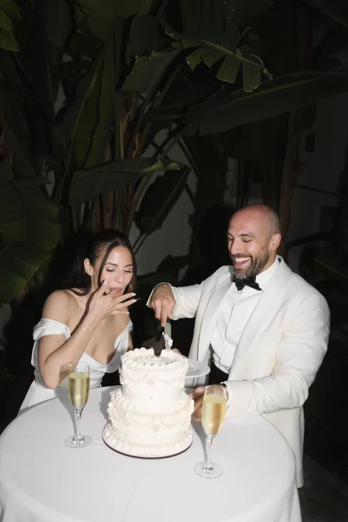 Bride and groom laughing while cutting their wedding cake at Masia Victoria.