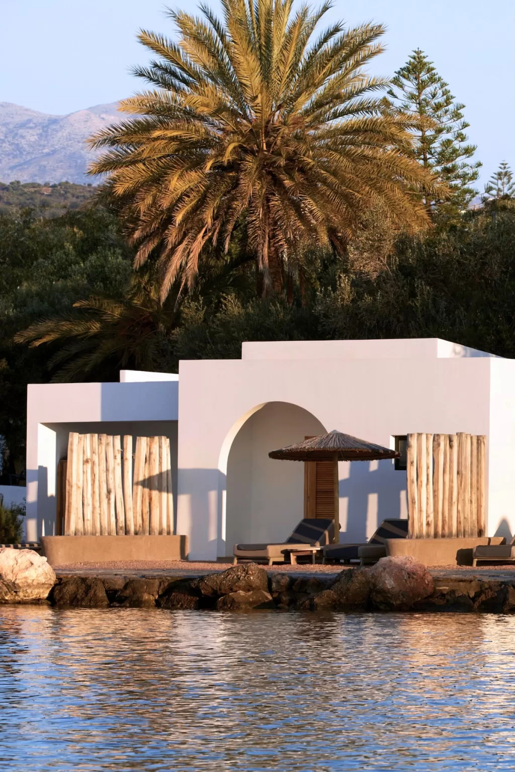 Waterfront villa with private pool and sun loungers at Minos Beach Art Hotel.