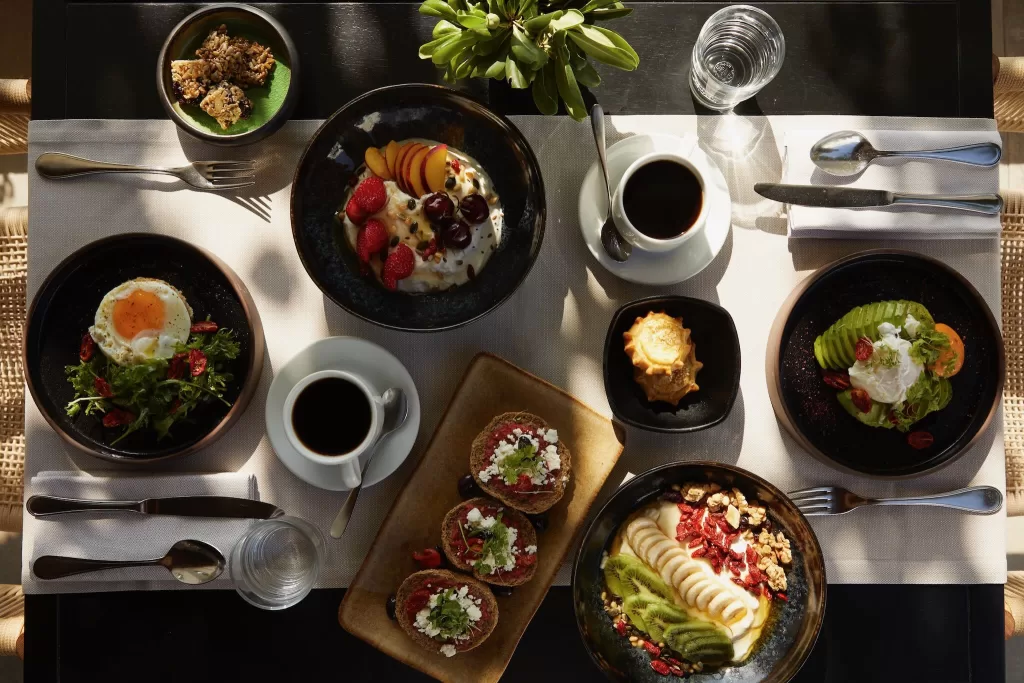 Gourmet breakfast spread with fresh fruit, eggs, pastries, and coffee at Minos Beach Art Hotel.
