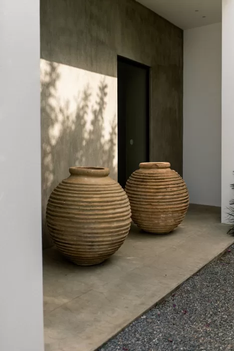 Pair of large ribbed terracotta pots outside a modern suite at Minos Beach Art Hotel.