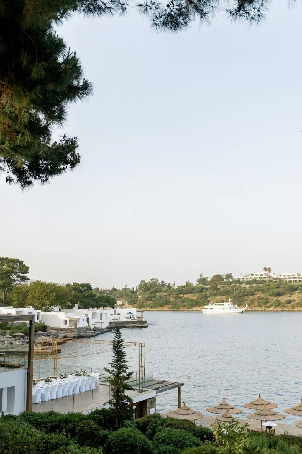 Scenic view of Minos Beach Art Hotel with white villas and reception area by the water.
