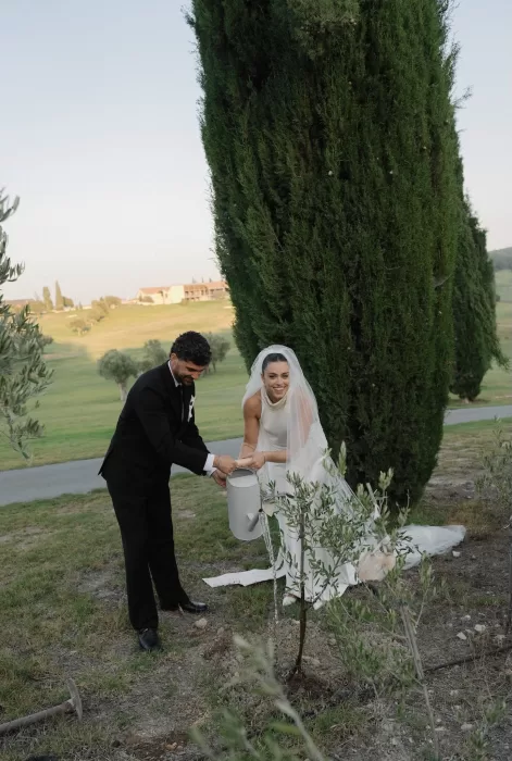 Bride and groom watering a newly planted tree together at Minthis Resort.