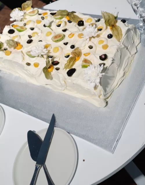 Rectangular wedding cake topped with fresh fruit and flowers at Minthis Resort.