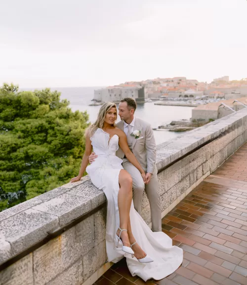 Couple seated on terrace ledge overlooking the Adriatic Sea at the Museum of Modern Art Dubrovnik.