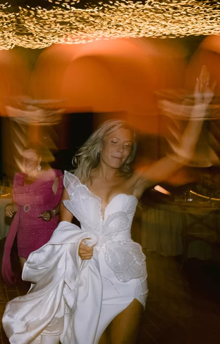 Bride dancing joyfully beneath glowing lights at Museum of Modern Art Dubrovnik wedding celebration.