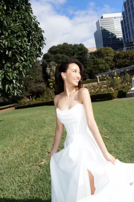 Bride in strapless white gown smiling in the garden at Next Chapter Events.
