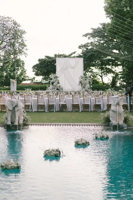 Elegant outdoor reception with long banquet tables by the pool at Padma Resort Legian.