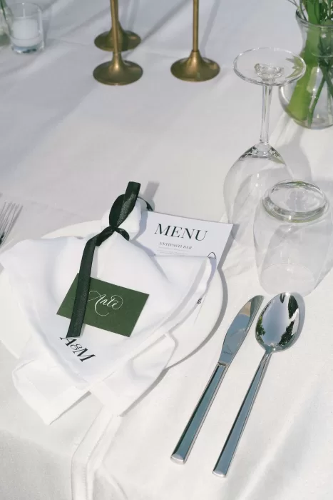 Elegant wedding table setting with menu, place card, and ribbon-tied napkin at Padma Resort Legian.