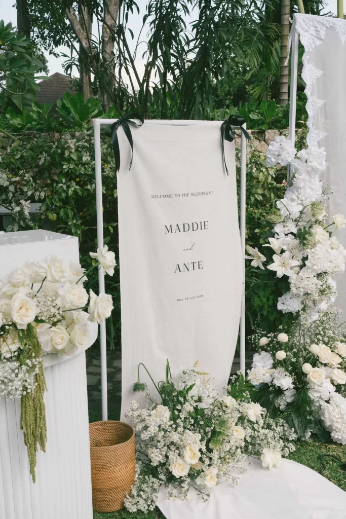 Wedding welcome sign with floral arrangements for Maddie and Ante’s celebration at Padma Resort Legian.