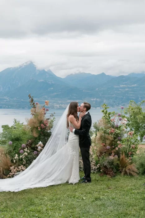 Bride and groom sharing a kiss during their outdoor ceremony with mountain views at Rustico Bertel.