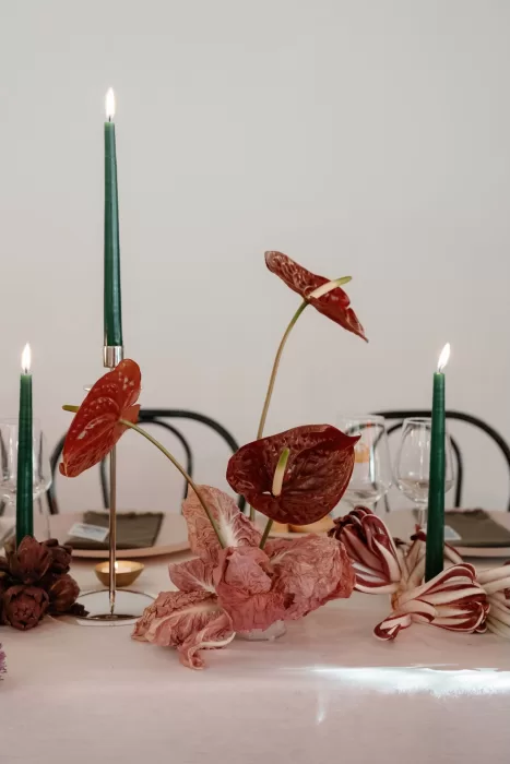 Modern wedding table styling with red anthurium flowers and green taper candles at Rustico Bertel.