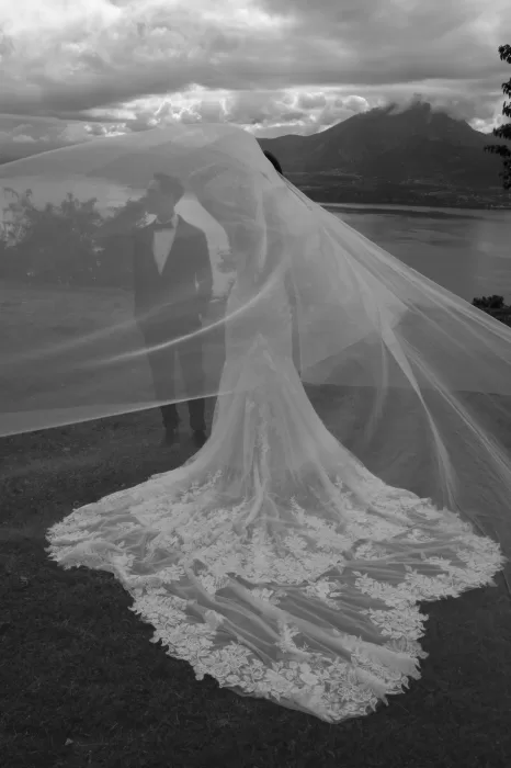 Romantic black and white portrait of the couple under the bride’s veil with lake and mountain views at Rustico Bertel.