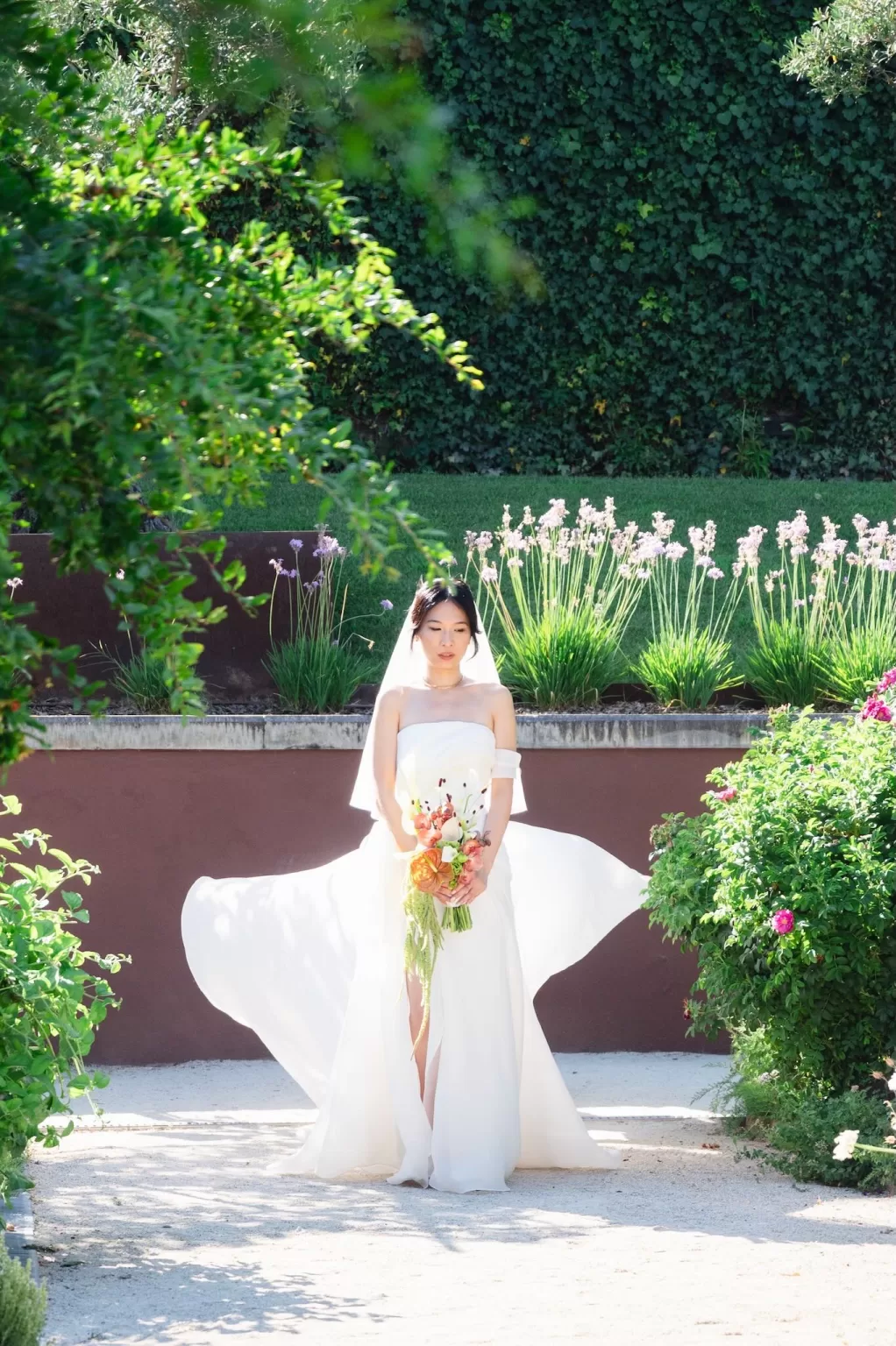 Bride holding a bouquet of orchids and anthuriums in the garden at Six Senses Douro Valley.