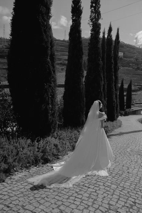 Black and white photo of bride with flowing veil on cobbled path at Six Senses Douro Valley.