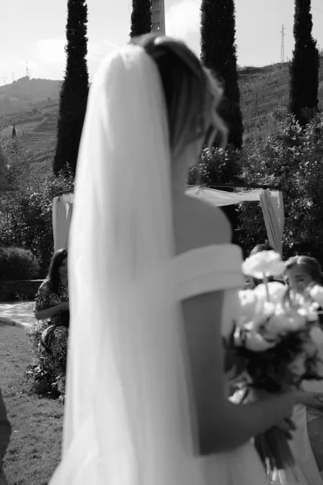 Black and white image of bride holding bouquet during outdoor ceremony at Six Senses Douro Valley.