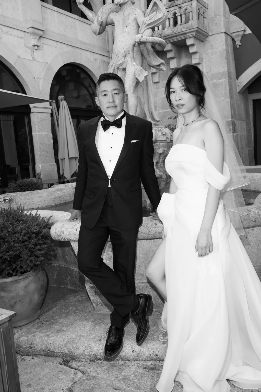 Black and white portrait of bride and groom by stone fountain at Six Senses Douro Valley.