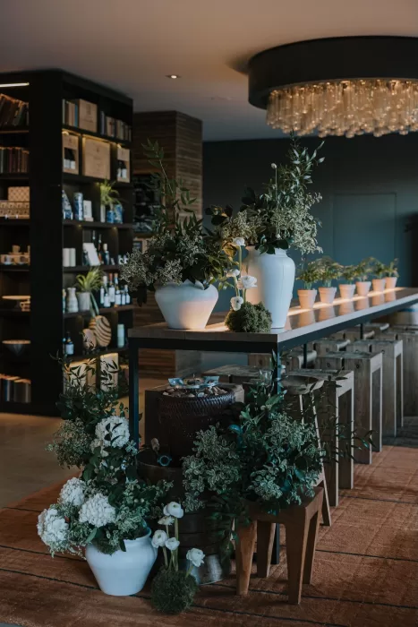 Modern indoor wedding decor with lush greenery and white flowers at Six Senses Douro Valley.