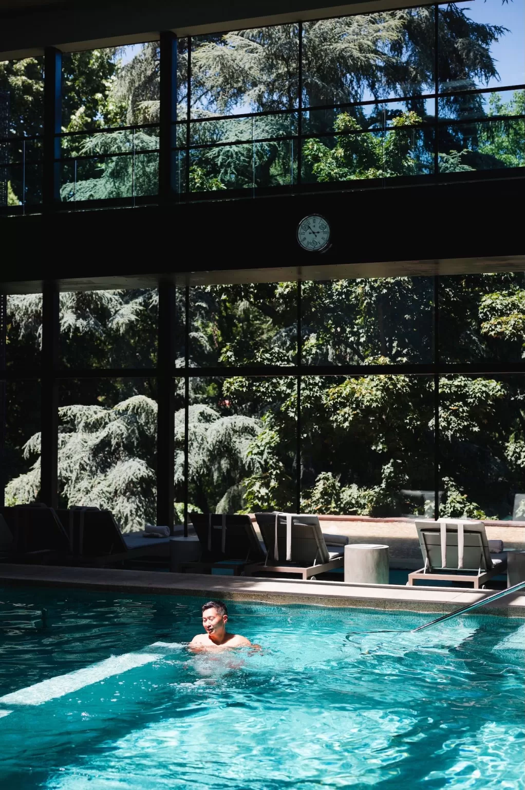 Guest swimming in the indoor pool with forest views at Six Senses Douro Valley spa.