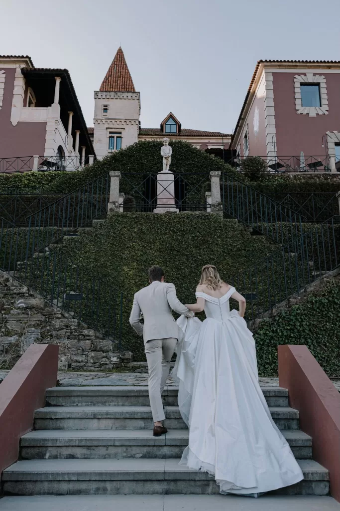 Bride and groom walking up grand stone staircase of Six Senses Douro Valley.